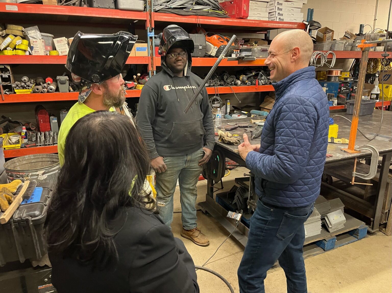 Landsman in workshop with welders