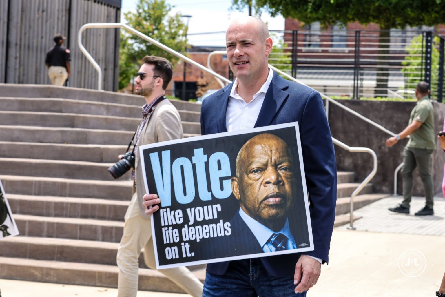 Landsman holding sign "Vote like your life depends on it"